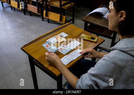 Izmir, Turkey. 14th May, 2023. An officer examines the voters' identities. Turkish voters proceed to their respective precincts to vote for their favored candidates in the 2023 presidential and parliamentary elections in Turkey. It is said that this is the biggest elections in Turkey history. (Photo by Murat Kocabas/SOPA Images/Sipa USA) Credit: Sipa USA/Alamy Live News Stock Photo