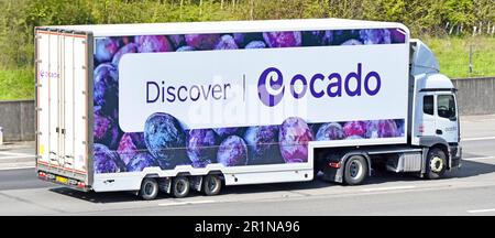 White hgv lorry truck power unit with aerodynamic deflector above cab  Discover Ocado banner across articulated semi trailer driving M25 motorway UK Stock Photo