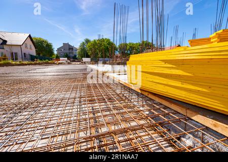 Perspective view on rusty, quadratic reinforcement, armature, mesh placed in foundation for concrete strength of residential building that is under co Stock Photo