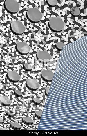 Abstract close up of architectural building cladding gray manipulated colour on circular raised panels chequered backdrop with grill lines England UK Stock Photo