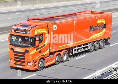 Scania 500S series hgv prime mover lorry truck graphic by Manfreight walking floor semi trailer haulage & logistics business on M25 motorway road UK Stock Photo