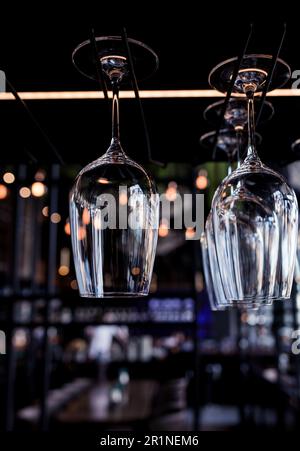 Clean wine glasses hang on the bar counter. Lots of empty wine glasses Stock Photo