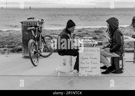 Two men playing a board game on Venice Boardwalk Stock Photo
