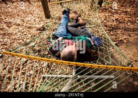 Above view of man and woman embracing lying down in hammock in fall Stock Photo