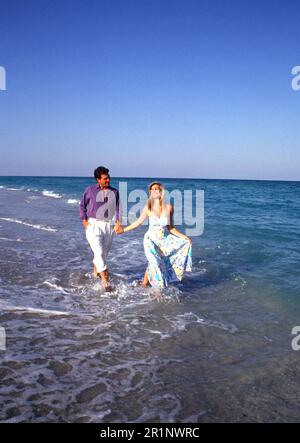 Attractive young couple walking on the beach Stock Photo