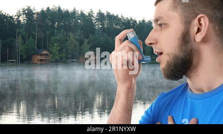 Man using asthma inhaler near lake. Emergency first aid during outdoor recreation Stock Photo