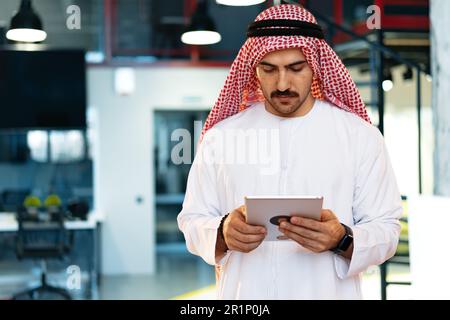 Arab muslim businessman using digital tablet in modern office Stock Photo