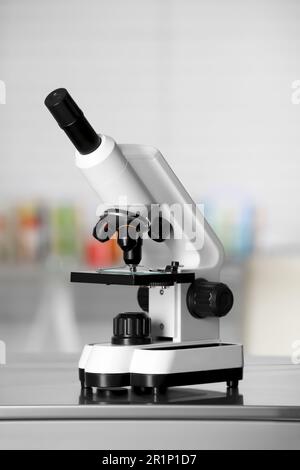 Modern medical microscope on metal table in laboratory Stock Photo