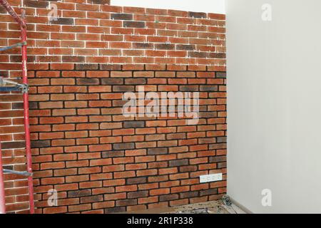 Decorative bricks with tile leveling system on white wall Stock Photo