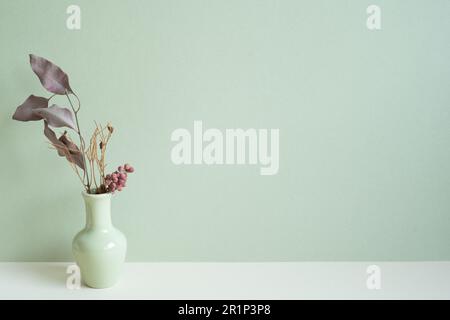Vase of dry flower on white table. mint wall background. copy space Stock Photo