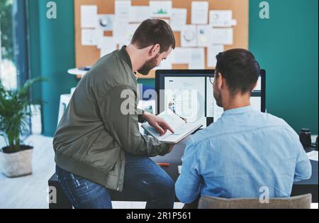 Theres a creative solution to every problem. Rearview shot of two young designers working together in an office. Stock Photo