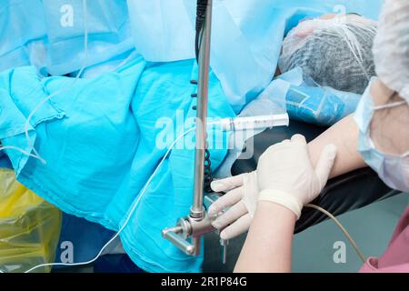 Selective focus on the syringe with anesthesia on the operating table. Administering an anesthetic to a patient during surgery. Stock Photo