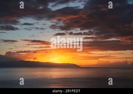 Dramatic sunset cloudy orange sky over the island La Gomera from Tenerife Stock Photo