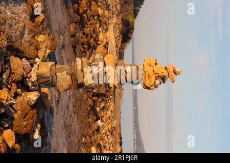 Cairn, tower of stones on the beach of Kiotari, Rhodes, Greece Stock Photo