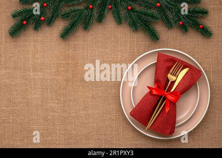 New Year's table setting with festive decorations. Invitation card for Christmas. An empty plate and golden cutlery on a jute tablecloth. View from ab Stock Photo