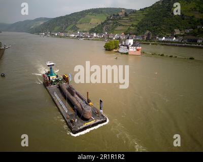 St. Goar, Germany. 15th May, 2023. The U17 submarine, which has been decommissioned by the navy, passes the Pfalzgrafenstein customs castle on the Rhine near Kaub (aerial photo taken by drone). On May 17, the 48-meter-long boat is scheduled to land in Speyer and be transported by road to the Technik Museum. Later, it will be on permanent display in Sinsheim (Baden-Württemberg). Credit: Thomas Frey/dpa/Alamy Live News Stock Photo