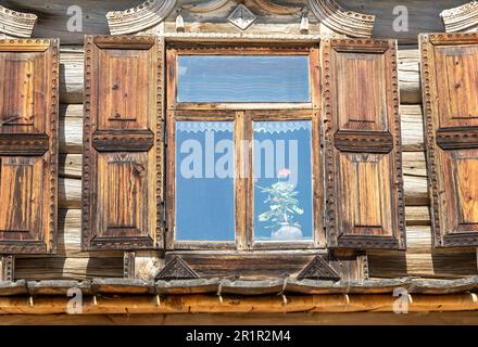 Windows of old traditional russian log house with carved wooden trim Stock Photo