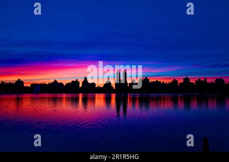 Sunset at Jacqueline Kennedy Onassis Reservoir, in New York City's Central Park silhouettes the iconic Central Park West skyline. Stock Photo