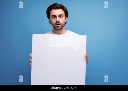 young brutal brunette guy with poster mockup Stock Photo