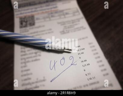 Bill and pen on dark wooden table, Bill for income and expenditure in still life tone Stock Photo