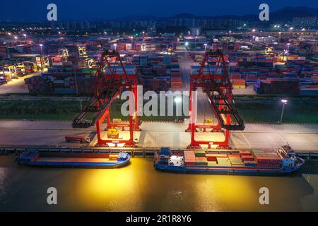 NANJING, CHINA - MAY 15, 2023 - Cargo ships load containers at the Longtan Container Terminal of Nanjing Port at night in Nanjing, Jiangsu province, C Stock Photo