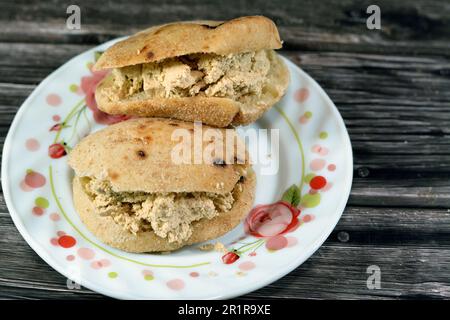 A sandwich of Traditional plain tahini halva or Halawa Tahiniya as basic tahini and sugar base inside a mini traditional Egyptian flat bread with whea Stock Photo