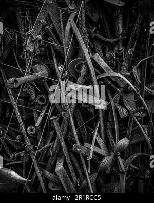 A pile of old, rusty tools including in grayscale Stock Photo