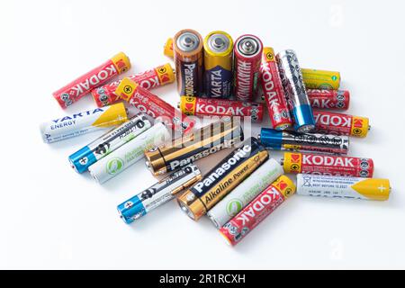 Warsaw, Poland - May 14, 2023: Pile of used batteries, different sizes and brands of batteries. Multicolored batteries on a white background Stock Photo