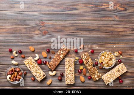 Various granola bars on table background. Cereal granola bars. Superfood breakfast bars with oats, nuts and berries, close up. Superfood concept. Stock Photo