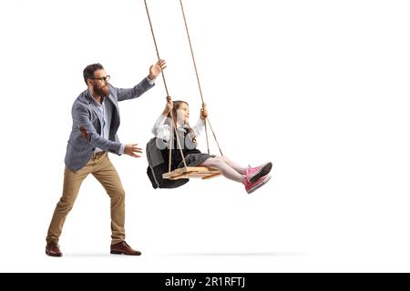 Full length shot of a man pushing a schoolgirl on a swing isolated on white background Stock Photo