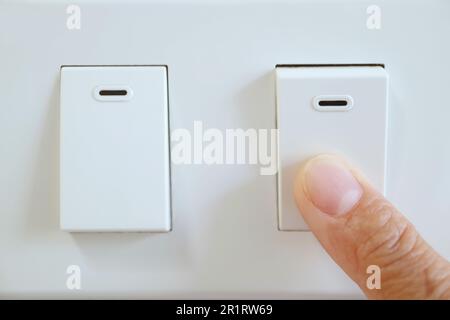 Finger pushing a switch for turn off light Stock Photo