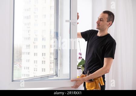 Worker in installing rubber seals on plastic upvc window. Stock Photo