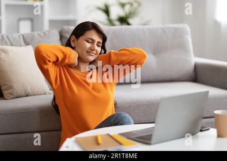 Tired young indian woman freelancer rubbing neck, home interior Stock Photo
