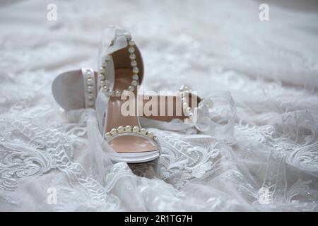 Detail shot of brides shoes and wedding dress before a wedding. Stock Photo