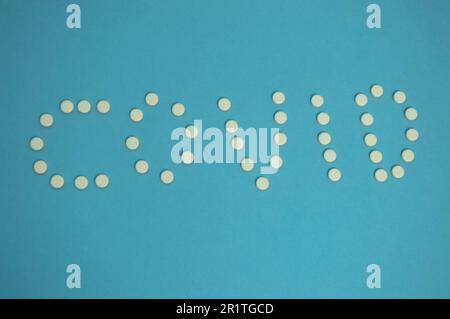 medicinal products are laid out in the form of a coronavirus. white pills on a blue background. Means for strengthening immunity from infectious disea Stock Photo