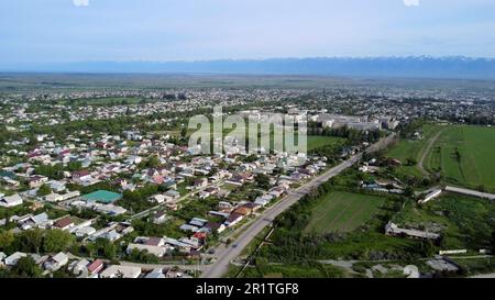 Aerial panorama of Karakol, fourth largest city in Kyrgyzstan, with the mountains in the background. Stock Photo