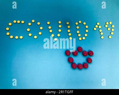 three-dimensional inscription of the letter from the tablets of bright color. word coronavirus with yellow round tablets. a bright pink volumetric cro Stock Photo