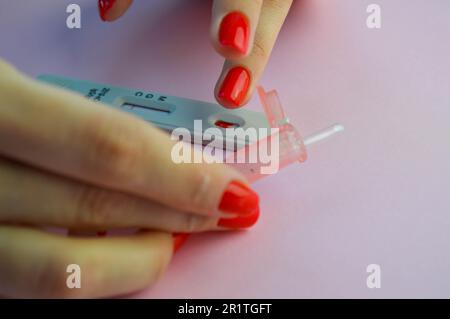 A Girl with a Bright Red Manicure Holds a Coronavirus Test and a Lancet for  a Blood Test in Her Hand. Determination of IgG and IgM Stock Photo - Image  of girl