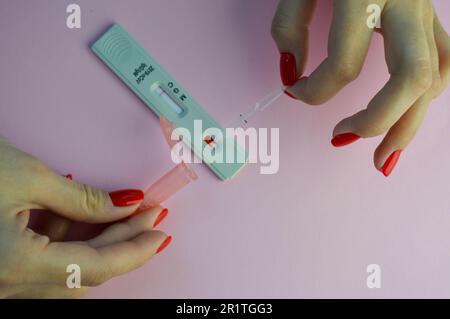 A Girl with a Bright Red Manicure Holds a Coronavirus Test and a Lancet for  a Blood Test in Her Hand. Determination of IgG and IgM Stock Photo - Image  of girl