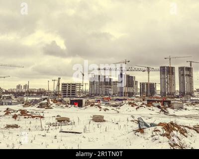 construction of houses, a shopping center from concrete blocks in the city. construction of a new residential quarter in winter. high, multi-storey bu Stock Photo