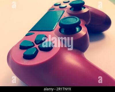 Beautiful red digital modern new game joystick for computer video games gamepad on a pink background. Stock Photo