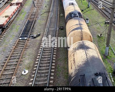 Top view of different railway wagons and tanks on an industrial railroad with rails for the transport of goods and improved modern logistics. Stock Photo