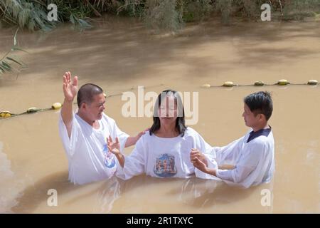 A visitor from the Philippines gets baptized in the Jordan River where Jesus was baptized. Stock Photo