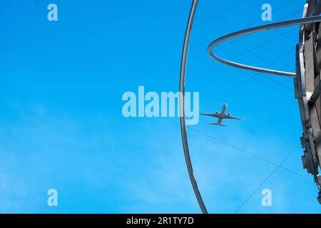 A plane taking off from La Guardia Airport and seen through the Unisphere in Flushing Meadows Corona Park in Queens, New York. Stock Photo