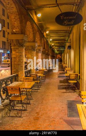 Passage with tables outside in front of a restaurant at night in winter in Oslo, Norway Stock Photo