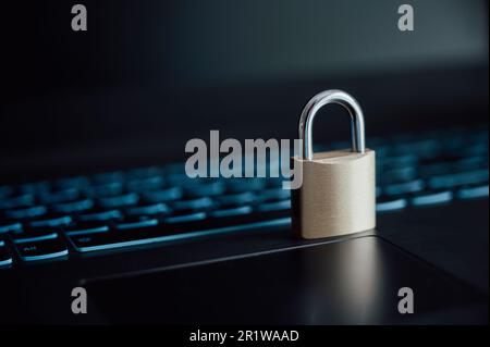 A golden padlock placed on laptop computer keyboard in a conceptual image of online cyber security. Stock Photo