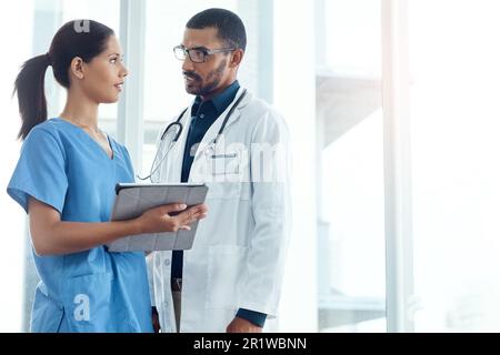 Integrating digital technology into their diagnosis. two young doctors using a digital tablet in a modern hospital. Stock Photo