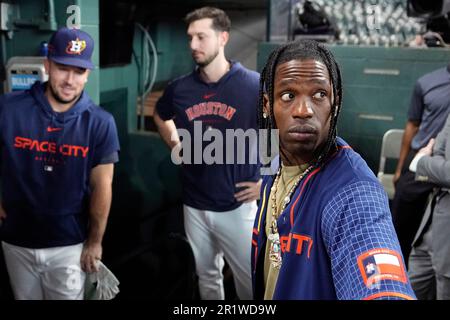 Houston rapper Travis Scott, right, is joined by Houston Astros Alex  Bergman, left, and Kyle Tucker, as he waits to hit before a baseball game  between the Chicago Cubs and Houston Astros Monday, May 15, 2023, in Houston.  (AP Photo/David J. Phillip Sto