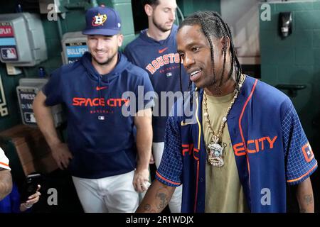 Houston rapper Travis Scott, right, is joined by Houston Astros Alex  Bergman, left, and Kyle Tucker, as he waits to hit before a baseball game  between the Chicago Cubs and Houston Astros