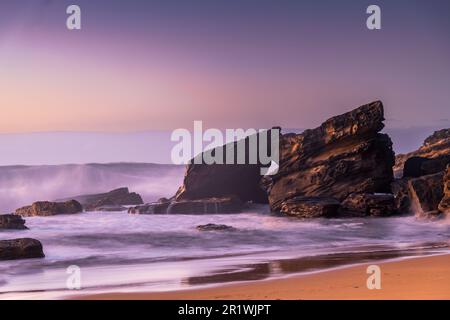 Sunrise seascape with large waves washing ashore at Killcare Beach on the Central Coast, NSW, Australia. Stock Photo